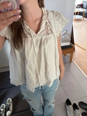 Vit blus med spets och volangärm - Söt vit blus med spetsdetaljer vid axlarna och volangärmar. Hör av er om ni har frågor💞