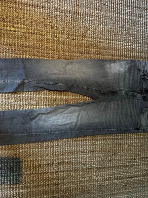 Grå slim fit jeans - Snygga grå slim fit jeans med slitningar och tvättade detaljer. Klassisk femficksmodell och smal passform som ger en modern look. Perfekta till en avslappnad stil och passar till det mesta i garderoben. 