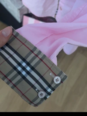 Rosa burberry skjorta - En såååå fin rosa burberry skjorta. Äkta i M. Men passar mig som xs! så xs/s mer skulle jag säga. inga defekter