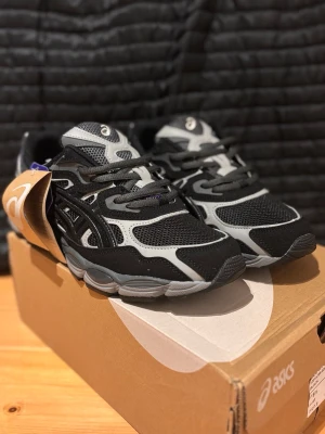 Asics sneakers - Snygga Asics sneakers i svart och grått med meshpaneler och detaljer i syntetmaterial. Skorna har en sportig design med Ortholite-innersula för extra komfort. Perfekta för dig som gillar streetstyle och sportig look.