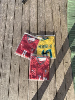 Fotbollströjor Portugal & Brasilien - Hej 👋 jag säljer nu 3 st fotbollströjor med Ronaldo, B. Fernandes och Neymar på ryggen!✅ Alla är i storlek M och är i helt nytt skick med prislapp kvar och tröjan kommer självklart i originalförpackning!📦 Jag kan självklart diskutera priset!💸 (Vill du bara ha en eller två av tröjorna? Kontakta då mig så löser vi det!)🫡.                          hej så länge!🙌💪🏽❤️