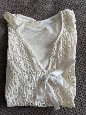 Vit top från Odd Molly, storlek M - Söt vit blus med korta ärmar, storlek 2 eller medium skulle jag säga. Framsidan har en dekorativ rosett. Hängd i garderob.