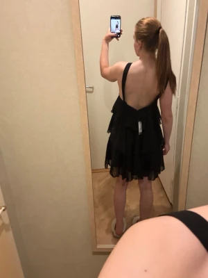 Svart volangklänning med öppen rygg - Säljer en svart klänning med flera lager volanger som är från Vera Moda i storlek S. Aldrig använd och prislappen sitter kvar. 