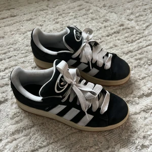 Adidas campus 00 storlek 43/1/3 - Säljer ett par Adidas Campus 00 i fint skick! Skorna är använda, vilket syns lite på mockan och sulan runt om, men i övrigt är de väldigt fräscha och fina.😊  Nypris 1449kr, mitt pris: 550kr STORLEK: 43/1/3