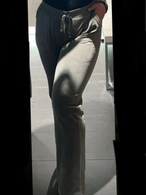 Grå Juicy Couture  - Snygga grå byxor i Juicy Couture i mjuk velour med raka ben. Byxorna har fickor på sidorna och en liten broderad detalj på ena fickan. Perfekta för chill dagar och riktigt sköna att ha på sig och är otroligt snygga också! Finns vissa tecken på användning så som viss missfärgning längst ned på byxan på baksidan(som i stort sett inte syns när man har de på sig) Samt att metall detaljerna på snörningen saknas( väldigt vanligt på dessa ) Bilder med mått finns! Matchande hoodie finns också till salu🌷