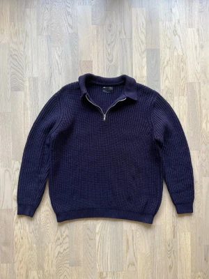 ASOS Design stickad halfzip-tröja - L, blå - Mycket bra skick. Inga tydliga tecken på användning  Halfzip-tröja från ASOS Design, storlek L, blå Tjock ribbad struktur och en normal-avslappnad passform. Halfzip med liten krage, muddar vid ärmslut. Använd, men i bra skick utan slitage. Tröjan är dock något nopprig på grund av materialet.  Bröstvidd: 56 cm Längd: 67 cm Inga defekter