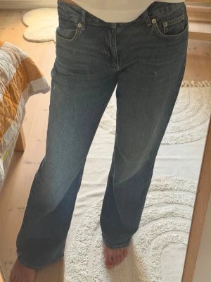 Mörkblå raka jeans med låg midja - Säljer ett par mörkblå jeans med rak passform och låg midja. Jeansen har klassiska fem fickor, knappgylf och är i ett mjukt denimtyg. Perfekta för en avslappnad och trendig look.