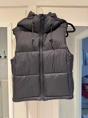 Svart dunväst med huva - Svart dunväst från Zara. Oanvänd. Storlek 34. Otrolig mjuk, generös huva, får plats med både frisyr och hörlurar under.