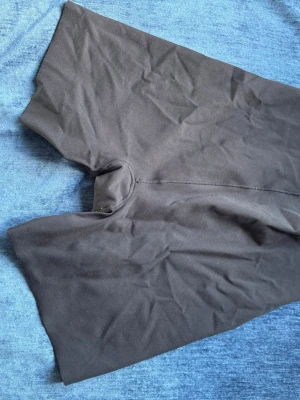Svarta cykelshorts leggings - Säljer ett par svarta cykelshorts i stretchigt material. De har hög midja och korta ben, perfekta till sommaren eller träning. Materialet känns mjukt och följsamt mot huden. Passar dig som gillar en enkel och clean stil.