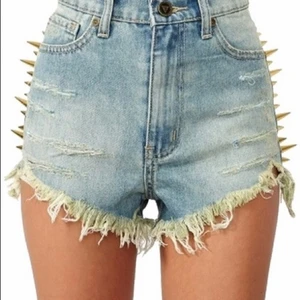 UNIF Back Off Spikes Shorts Nyskick - Snygga äkta jeansshorts från UNIF Clothing i blå jeansfärg i modellen ”Back Off” och storlek 25. Super coola med guld nitar på sidorna och snyggt slitna vid köp som nu (meningen) . Endast använda fåtal gånger när de var nyinköpta för ca 8 år sedan så helt i nyskick. Köptes på dollskill hemsida för ca 1500:- med frakt + tull avgifter. Säljes då de är alldeles för små nu och kommer aldrig till användning längre. Hoppas de gör någon annan glad!
