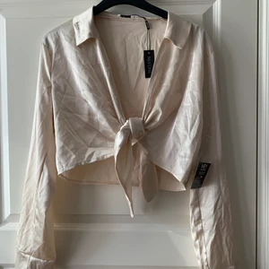 Croppad blus - Croppad blus, aldrig använd, lappen är kvar. Är i siden material och är i storlek L men skulle säga mer som en S