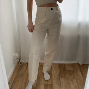 Ljusbeigea byxor  - Ljusbeiga byxor från Nakd, strl 36. Aldrig använda med lappen kvar. Tygskärp i samma färg medföljes. Frakt tillkommer. 
