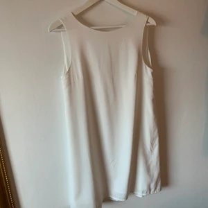 Studentklänning! - Superfin och elegant klänning perfekt till student/avslutning. Den är rak i passformen och ganska hög i halsen så väldigt simpel framtill. Men i ryggen har den finaste öppningen med ett mönster som liknar spets😍