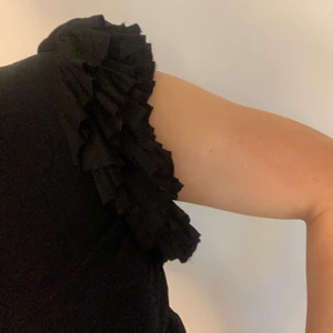 Matthew Williamson klänning - Underbar kort klänning i glansigt material med snygg volang/puffärm, inte använts så mycket då jag är lite för lång för den här modellen (176). Detaljer i grönt i fodret.