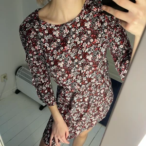 Blommig klänning - Fin blommig klänning med små volanger på axlarna. Slutar på mitten på låren på mig som är 171 cm lång. Använd endast 2 gånger.