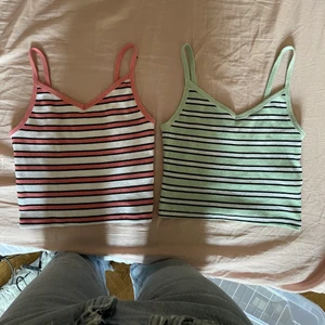 Randiga linnen - Två randiga linnen med svarta och vita ränder, det ena är ljusgrönt och det andra ljusrosa. Ganska stretchiga så passar upp till storlek s. 50kr styck eller båda för 75kr. Kan mötas i Stockholm annars betalar köpare frakt. Skriv privat för fler bilder!