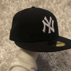 New Era 59Fifty - Säljer min svarta fitted New era keps. Inga tecken på andvändning finns och har endast andvänt den 3 gånger. Jag skulle säga att den är i nyskick. Måttet är 55,8 cm runt huvet vilket motsvarar storlek 7. Köpte kepsen från hatstore för någon månad sedan men har inte vetat om jag skulle ha kvar den eller inte pga storlek. Nypris: 450 kr  och säljer den för 250 kr (för mer bilder skriv) ❤️ obs inte såld