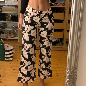 Blommiga LIAUORISH byxor - Köpte dessa byxorna för ca 3 år sedan men dem är aldrig använda. Väldigt fint skick! Kommer tyvärr inte ihåg vad jag köpte dem för men deras byxor brukar ligga runt 500kr. Säljer pga att de är för korta för mig. (Jag är 180cm). Köparen står för frakten.