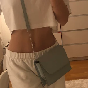 Väska - Säljer denna ljusblå väska från pull & bear som man kan göra både kort och längre! Använt fåtal gånger så alltså i nyskick, super snygg och passar till allt