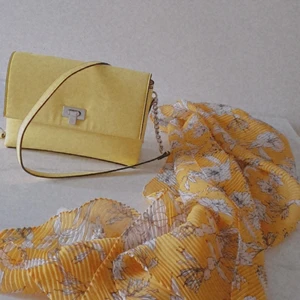 guld väska med gul halsduk  - Den är helt ny köpt från Tyskland men för jag inte tycker gul färge så jag vill sälja de båda två. Bara väska kostar 149kr och halsduk kostar 99kr. Men om du köper båda kostar 229kr