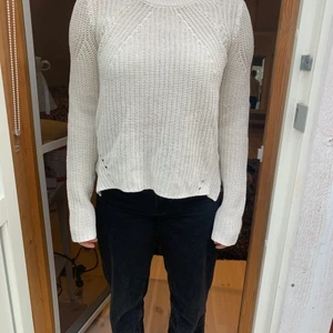 Stickad tröja från HM - Fin stickad tröja från HM. Den är i en benvit/ beige färg och har väldigt fina detaljer. Tröjan är gammal men i fin skick.