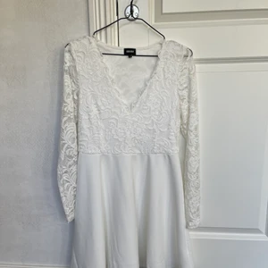 Vit student/avslutningsklänning  - Vit student/ skolavslutnings klänning från bubbleroom storlek M  Använd 1 gång  Lite grön vid urringningen från en ros men det ska gå att få bort om man anstränger sig lite