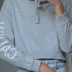 Fin kortare huvtröja från Calvin Klein✨ - En riktig croppad grå huvtröja från Calvin Klein där det står Calvin och Jeans på armarna och Klein på ryggen. Köpte den för bara ca 1 år sedan och har inte används så mycket. Är i mycket bra skick. Köptes för ungefär 700kr.😊 