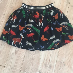 Kjol med djur  - Detta är en kjol i storlek 158/164 och jag rekommenderar för ni dom är 12-14 år gamla. Den är i ett tunt blus material och mörkblå med olika djur som har olika färger. Det är ett väldigt luftigt och skönt material för sommaren. Man kan matsha med en brun topp till eller en svart enligt mig.🦋
