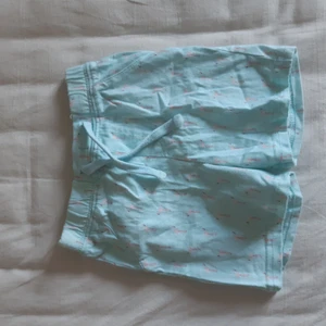 Shorts med flamingo på från Mywear Baby - Aldrig använt så skicket är bra men lite skrynklig. Resårband är töjbar och bra. 