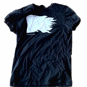 J Lindeberg T-shirt ”flag” - Svart T-shirt från J Lindeberg med flagga på framsidan. Nypris 700 kr. Storlek medium men sitter rätt tight så skulle säga small i passformen.