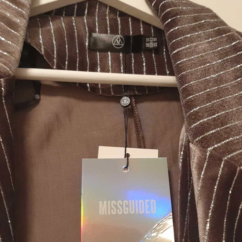 Nytt kostymset från missguided. Lappar fortfarande kvar! Setet är grått i velour med silvriga glittriga ränder. Överdel storlek 42 och underdel storlek 40.. Kostymer.