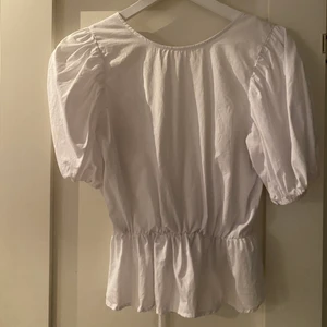 vit volang topp - vit volang topp med puffarmar och öppenrygg med knytning från nelly