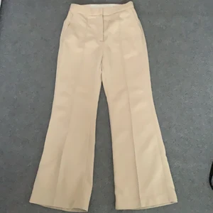 Kostymbyxor H&M - Beigea kostymbyxor köpta från H&M som sitter fint i midjan, djupa fickor framme, en tråd som sitter löst annars felfri frakt ingår!