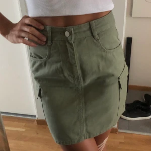 Kjol  - Kjol i khaki-grön färg. Denimtyg. Sitter bekvämt och lätt att gå i. 