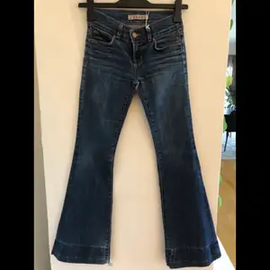 Lågmidjade bootcut jeans från JBrand i storlek 24. Välanvända jeans och detta märks längst ner då dem är slitna och även bak på jeansen. Originalpriset på dessa jeans är cirka 2000kr.