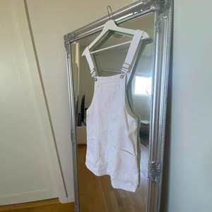 En vit hängselklänning, perfekt till sommaren men även till hösten att ha en tjockare tröja undertill. 