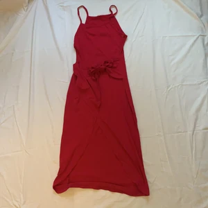 Rosa klänning - Rosa klänning i stretchigt tyg med knytning framtill och slits, från märket Stefanie. Vet tyvärr ej storleken då det ej finns en lapp men den är som sagt väldigt stretchig så tror den passar de flesta storlekar 