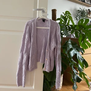 Stickad cardigan från Lindex - 🌸Virkad cardigan i ljus lavendelfärg från Lindex. Helt i nyskick, endast använd 2 gånger.                                                              🧥 Storlek S, men passar även dig som bär XS. Jättehärligt material, varken stixig eller kliande. Nypriset när jag köpte den var 349kr, är nu slutsåld på nätet. Säljer min för 250kr. 📦 Skicks med post, köparen står för frakten (62kr). Om intresset är stort är det högst bud som gäller. Annars är priset diskutabelt.