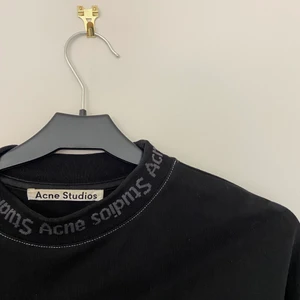 ACNE STUDIOS SWEATSHIRT SVART XS - Tröja från Acne Studios med logga på krage och ärmslut. Svart med vita kontrastsömmar. Storlek XS men sitter oversized, passar även S och M. Knappt använd så den är i nyskick!