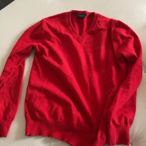 Röd stickad tröja - Fin röd stickad tröja med ett märke på bröstet. Från märket boomerang. Väldigt fint skick. Köpte secondhand för ett år sedan men använder inte pga inte min stil längre