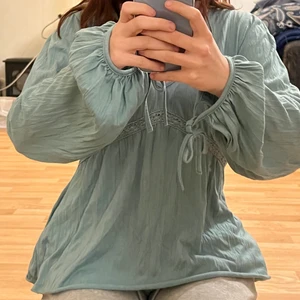 Blågrå blus - Blågrå blus, med lite ballongärmar med snörning. Storlek L och skulle säga att den är bra till storlek :)