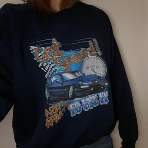 Trendig mörkblå sweatshirt med tryck  - Trendig mörkblå sweatshirt med tryck som är köpt på en secondhandbutik. Tröjan är som i nyskick och knappt använt. Den är oversized i storleken på mig som vanligtvis har S eller M. Skriv om du har frågor! 