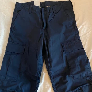 carhartt cargos - nya mörkblåa cargos från carhartt! köpta från zalando för ett tag sen men är nu helt slutsålda. storleken är 31x32. köparen står för frakt! 
