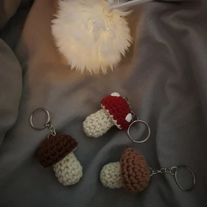 Nyckelring - Svamp - Egenvirkade svamp nyckelringar. Dessa söta svampar kommer i 3 olika färger: Röda med vita prickar, bruna och ljusbruna. Svamparna är ca 5cm × 4cm. De är virkade i bomull🌟 ◇Har även möjlighet att göra andra färger! 15kr i frakt tillkommer🌸
