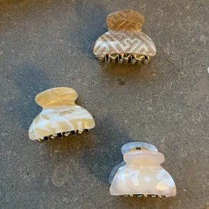 Hårklämmor små  - Jag säljer tre olika små hårklämmor en glittrig, en ljus rosa och en gul/guldig. De kostar 29 kr styck men det är ett paket pris på 69 kr för allihopa tillsammans. De har ett väldigt bra grepp och är helt oanvända endast provade för bilden. 