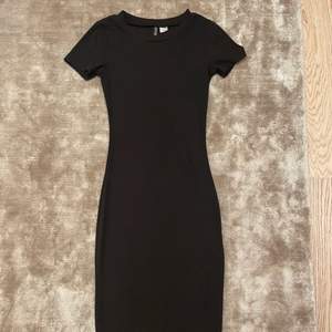 En svart figursydd klänning från H&M i storlek XS, klänning slutar vid knäna.