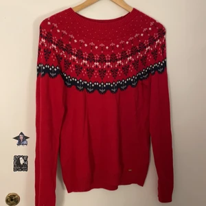 Stickad tröja med mönster - En röd stickad tröja med mönster på axlarna och bröstet. Helt oanvänd. Den är köpt på Kappahl med märket Hampton Republic. 