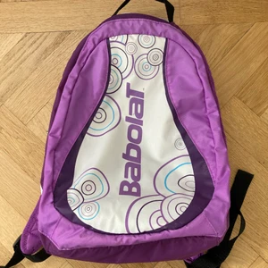 Tennisväska liten - Avsedd för tennisracket, men funkar utmärkt för vardaglig användning. Sparsamt använd, så inga tydliga märken. Ena dragkedjan funkar inte, så det går inte att möta de båda låsen på mitten. Istället får man dra den ena hela vägen till andra sidan (som en vanlig väska).