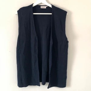 Stickad väst strl:42/44 - En mörkblå stickad väst med knappar. Strl:42/44.  Köparen står för fraktkostnaden😊