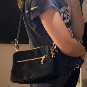 Svarat väska  - Svarat väska med bed band som man Kan ändra längs på, den har 3 stora fack och ett litet på sidan 